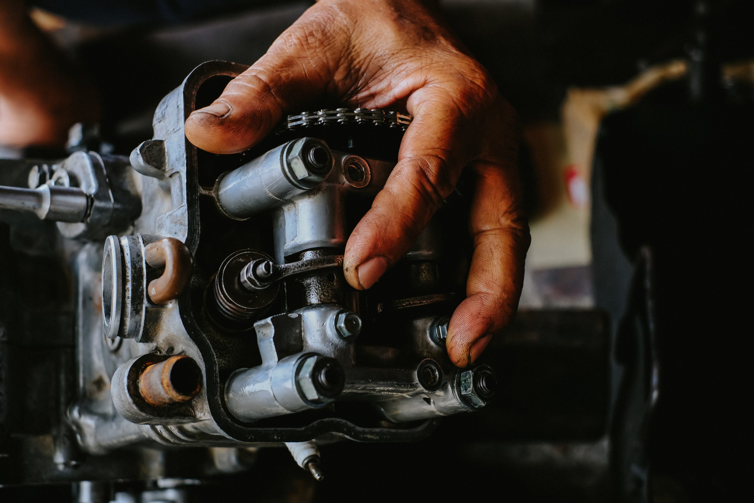 Mechanic's hands on motorcycle engine.